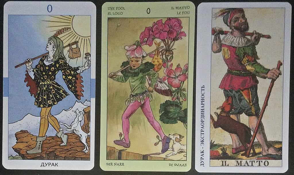 Три карты Таро рядом: «Дурак», The Fool и Il Matto — на каждой странник с котомкой на палке и собакой у ног